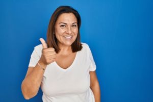 woman smiling doing thumbs up for implants