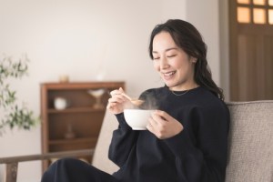Woman sitting on couch with bowl of soup